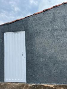 a white door on the side of a building at Toca do Tatu in Itu