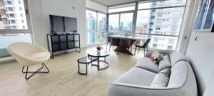 ein Wohnzimmer mit einem Sofa und einem TV in einem Gebäude in der Unterkunft Splendid Apartment City Center - PH Quartier Atlapa in Panama-Stadt