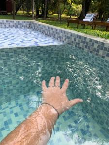 a persons hand in the water in a swimming pool at CASA-BOSQUE-ARROYO in Colón