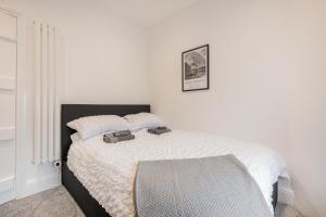 a bedroom with a bed with two bags on it at Southend Cottage in Penrith