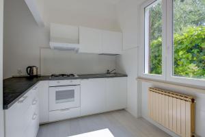 a kitchen with white appliances and a window at Appartamento Rupestre in Manerba del Garda
