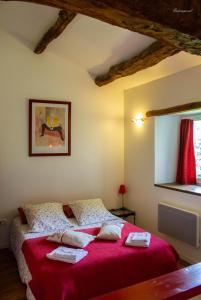- une chambre avec un lit doté d'une couverture rouge et d'une fenêtre dans l'établissement Chambre d'hôtes Puech Noly, à Mont-Roc