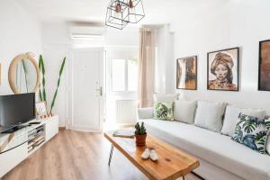 a white living room with a white couch and a table at Santa Triada in Heraklio