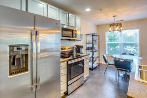 uma cozinha com um frigorífico de aço inoxidável e uma mesa em Pet-Friendly North Carolina Condo with Pool Access! em Southport