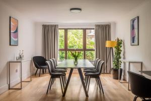 comedor con mesa, sillas y ventana en Monarch House - Serviced Apartments - Kensington en Londres