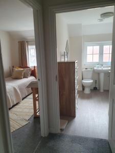 a bedroom with a bed and a sink and a toilet at Bright room with private toilet and shared bathroom, suitable for a professional 