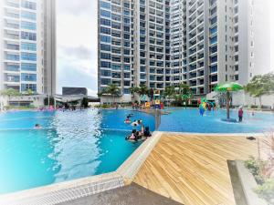 a large pool with people in it with tall buildings at JZstay - Atlantis Residences Melaka - 1BR & 2BR in Melaka