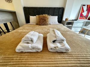 1 dormitorio con 1 cama con 2 toallas en BAHIA INFINITA en Ushuaia