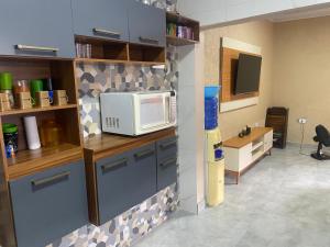 a kitchen with a microwave on top of a counter at casa_litoral_mongagua_2022 in Mongaguá