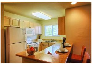 a kitchen with a white refrigerator and a counter top at Escape to Tropicana, a Tranquil Condo Oasis Near the LV Strip - Special Offer Now! in Las Vegas