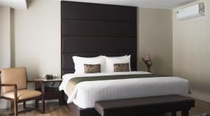 a bedroom with a large bed with a black headboard at Canyon Hotels & Resorts Boracay in Boracay +70 photos