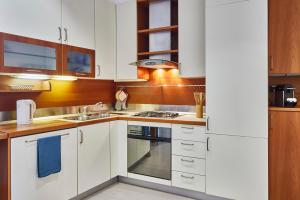 una cucina con armadi bianchi e piano cottura di Arc of Peace - Exclusive Apartment a Milano