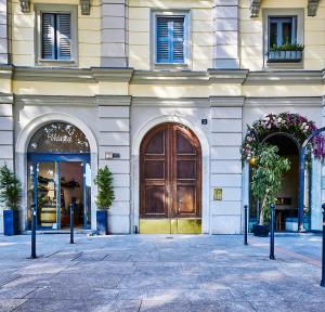 un edificio con una gran puerta de madera en una calle en Arc of Peace - Exclusive Apartment en Milán