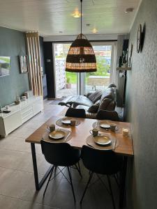 uma sala de estar com uma mesa de madeira e cadeiras em La Cabane de la mer em Bredene