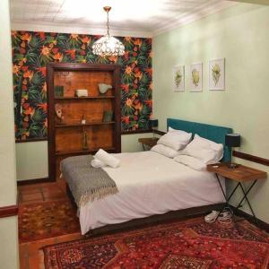 - une chambre avec un lit, une table et un tapis dans l'établissement Cosy Bachelors, 2 min walk to Melville 7th, à Johannesbourg