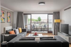 a living room with a couch and a tv at Monarch House - Serviced Apartments - Kensington in London