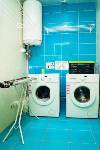 a blue tiled bathroom with a washing machine and a washer at DREAM Hotel Kyiv in Kyiv