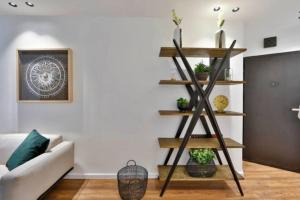 een woonkamer met een plank met planten erop bij 2Bedroom Suite with balcony ShenkinHotel in Tel Aviv