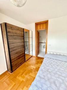 a bedroom with a bed and a wooden door at Appartamento nel verde fronte ospedale San Pietro, Sant'Andrea in Rome
