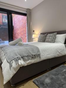 um quarto com uma cama grande e uma janela em Richardson Deluxe Apartments em Londres