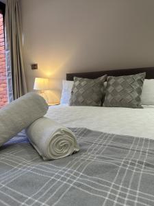 a bed with a white pillow on top of it at Richardson Deluxe Apartments in London