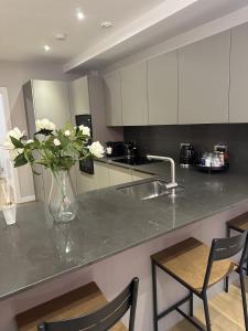 a kitchen with a vase of flowers on a counter at Richardson Deluxe Apartments in London