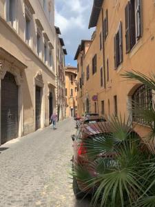 a person walking down a street next to buildings at Farnese Muse in Rome