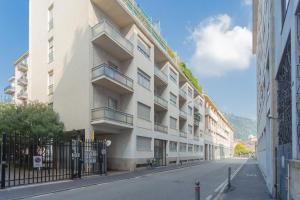 um edifício de apartamentos numa rua com uma cerca em Marcello's Como Lake em Como