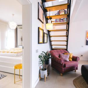 a living room with a spiral staircase next to a bed at Todor boutique house in Sremska Kamenica