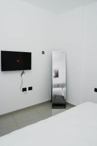 a white room with a television on a wall at The best location in Jerusalem 1 in Jerusalem