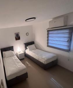a bedroom with two beds and a window with a blind at The best location in Jerusalem 1 in Jerusalem