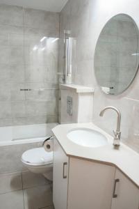 La salle de bains est pourvue d'un lavabo, de toilettes et d'un miroir. dans l'établissement The best location in Jerusalem 1, à Jérusalem