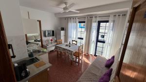 cocina y sala de estar con mesa y sofá en Vivienda Vacacional Tienda Loly, en Puerto de las Nieves