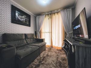 a living room with a couch and a flat screen tv at Apartamento super agradável! Perto de tudo em Águas Claras in Brasilia