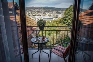 a balcony with a table and a view of a city at Plavo oko in Sarajevo