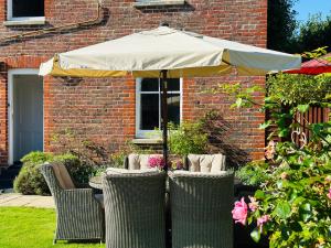 a group of chairs sitting under an umbrella at Saddlers B&B in Funtington