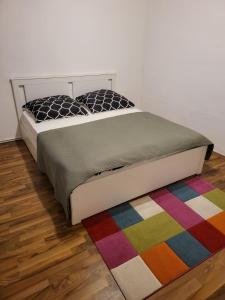 Bett in einem Zimmer mit farbenfrohem Teppich in der Unterkunft Mara in Neuhaus an der Pegnitz