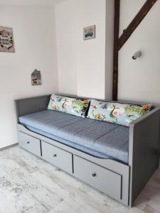 a bed with two pillows on it in a room at Apartment By the River in Niš