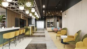 a lobby of a restaurant with chairs and a bar at B&B HOTEL Kielce Centrum in Kielce