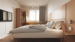 a bedroom with a bed with a lamp on it at B&B HOTEL Kielce Centrum in Kielce