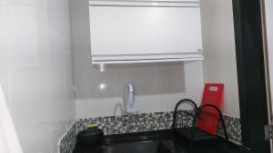 a kitchen with a sink and a white cabinet at Lofts da Monica in Rio de Janeiro