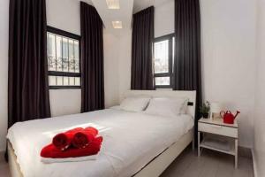 a bedroom with a white bed with two red roses on it at 2Bedroom Suite Shenkin Hotel in Tel Aviv