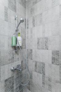 y baño con ducha con cabezal de ducha. en Lovely Apartment with Private Terrace by URBAN RENT, en Kaunas