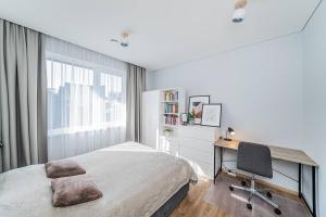 1 dormitorio con cama, escritorio y silla en Lovely Apartment with Private Terrace by URBAN RENT, en Kaunas
