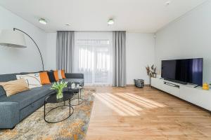 a living room with a couch and a flat screen tv at Lovely Apartment with Private Terrace by URBAN RENT in Kaunas
