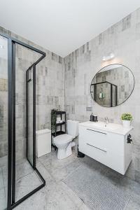 a bathroom with a toilet and a sink and a mirror at Lovely Apartment with Private Terrace by URBAN RENT in Kaunas