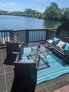 a deck with chairs and a table and a view of a lake at Scenic Carolina Waterfront Rentals - Arco in Charleston