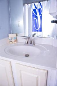 Baño blanco con lavabo y espejo en Scenic Carolina Waterfront Rentals - Arco, en Charleston