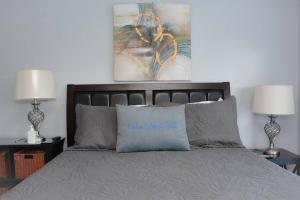 a bedroom with a bed with two lamps and a painting at Scenic Carolina Waterfront Rentals - Arco in Charleston