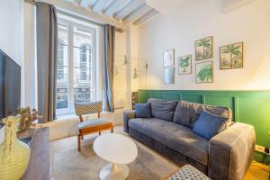 a living room with a couch and a table at La Rue in Paris
